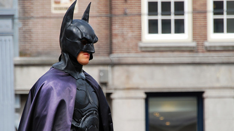 a man in a Batman costume on a city street