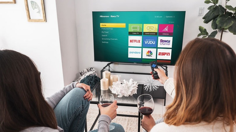 Two women watching a 4K smart TV with streaming apps