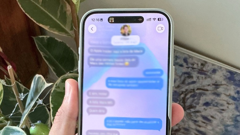 A hand holding an iPhone with iMessage app opened up