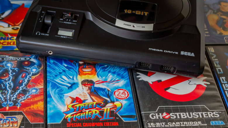 A pile of video games in front of a Sega Mega Drive