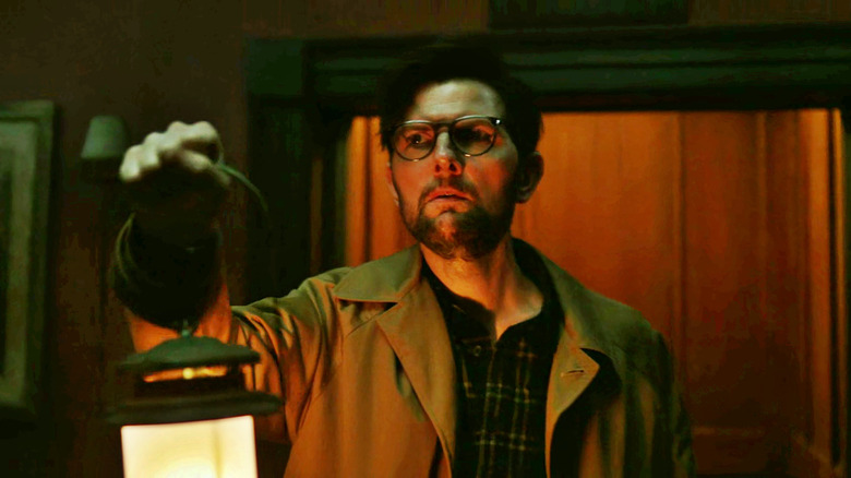 Ohm Bauman holding a lantern in fear.