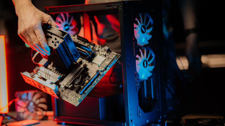 A person opening and disassembling a PC rig, taking the motherboard out