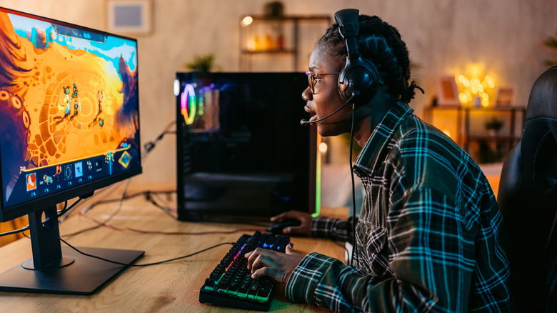 a person actively gaming on a pc while using a keyboard and mouse
