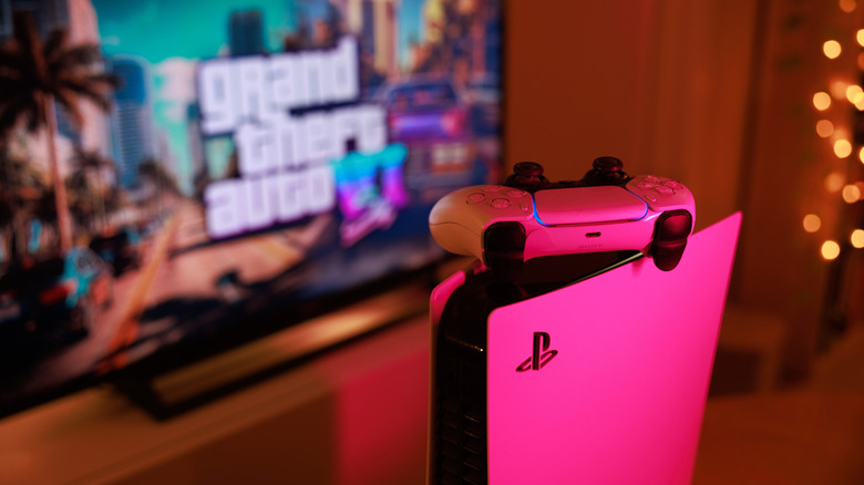 PlayStation 5 console with a controller on top in front of a TV with 'Grand Theft Auto 6' displayed