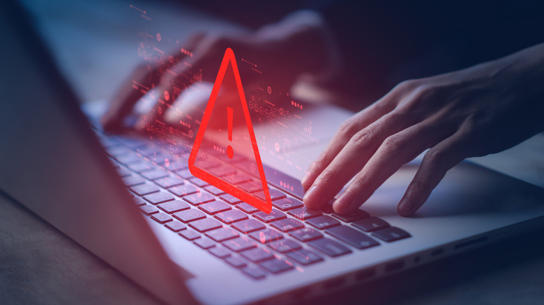 Artistic representation of a red triangle warning on top of a laptop keyboard