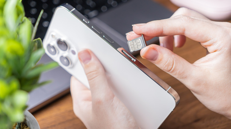 A person adding a micro SIM card to a phone