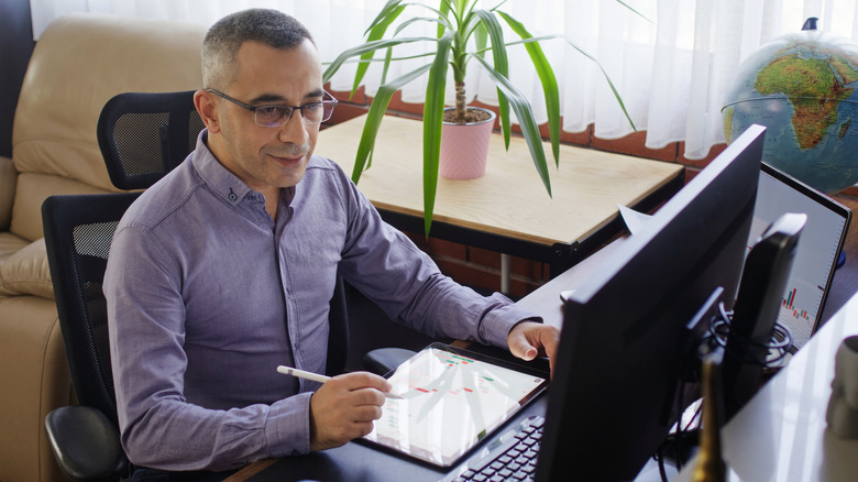 Man in office setting using desktop with monitor in front of him