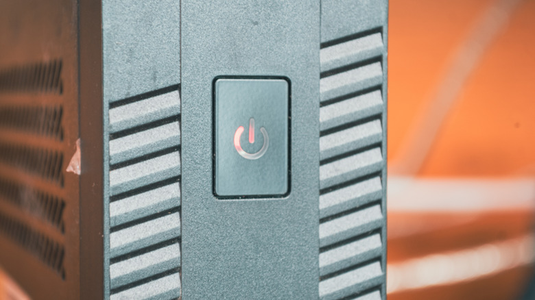 A close-up of a desktop PC's illuminated power button on the front panel of a computer case.