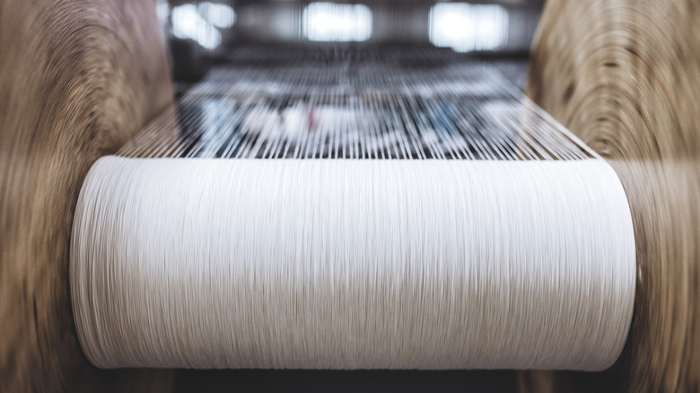 Silk yarn on a spool, set to be crafted into fabric products.