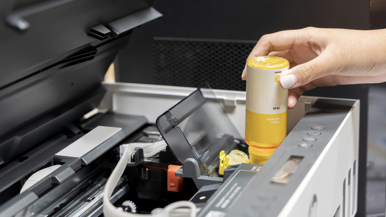 A person replacing a single-use printer cartridge
