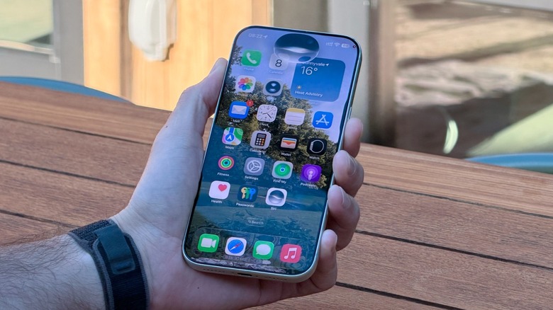 A hand holding an iPhone using Siri Ai