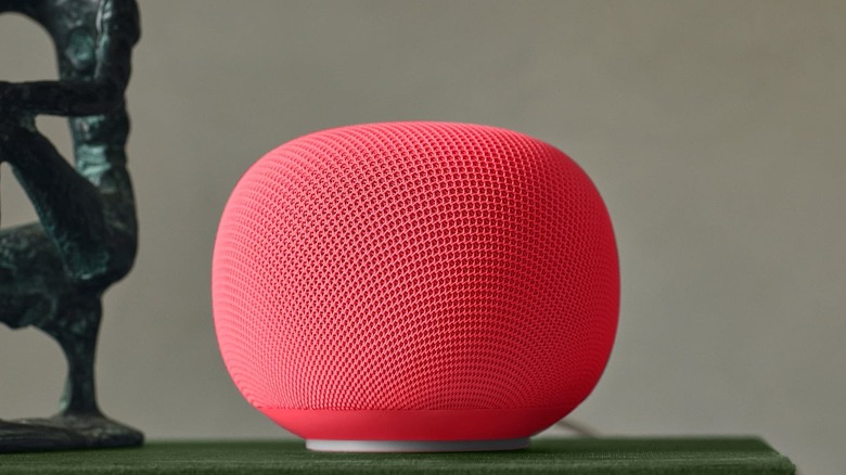 google home speaker in red color sitting on a stack of books