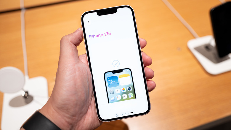 Hand holding iPhone 17e with the name of the phone on the setup screen