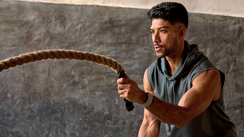 A man doing rope exercises while wearing the Garmin CIRQA smart band.