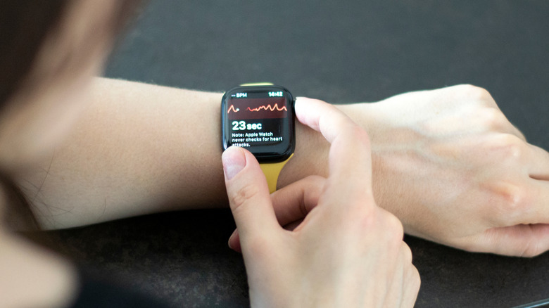 Apple Watch on woman's wrist with heart rate reading showing
