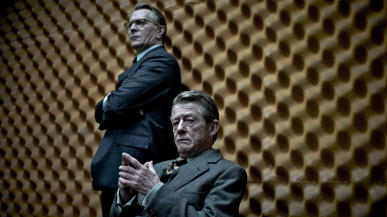 George Smiley standing next to a sitting Control