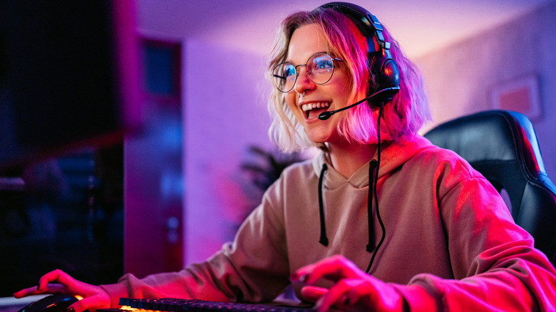 girl gaming on a pc with headphones on