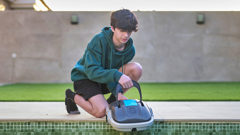 Boy using robotic pool cleaner
