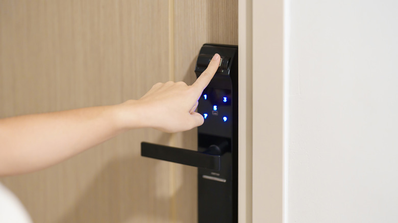 A person activating a smart lock system on a home door.