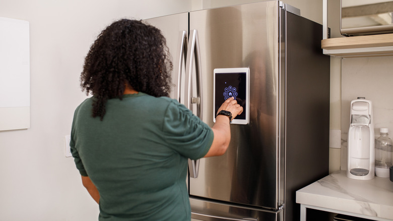 A person interacts with a smart refrigerator