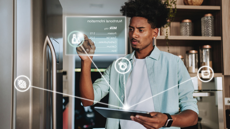 A person using an app to program a smart refrigerator