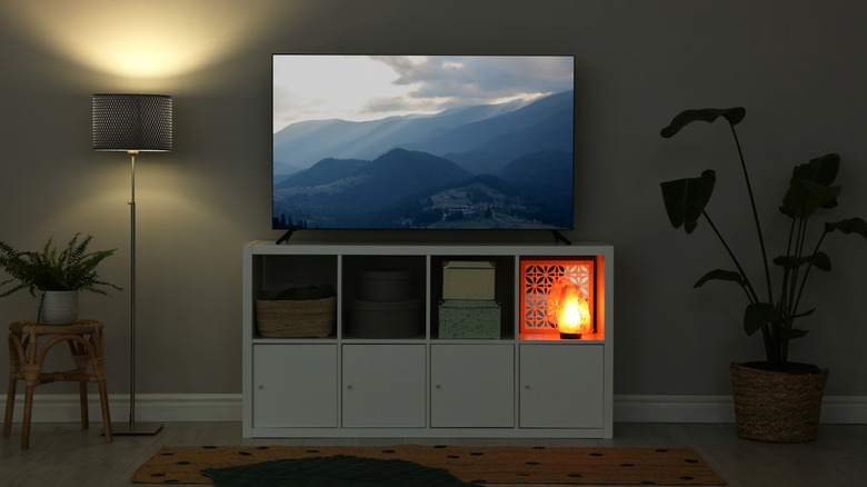A smart TV with the display on in a dimply lit room.