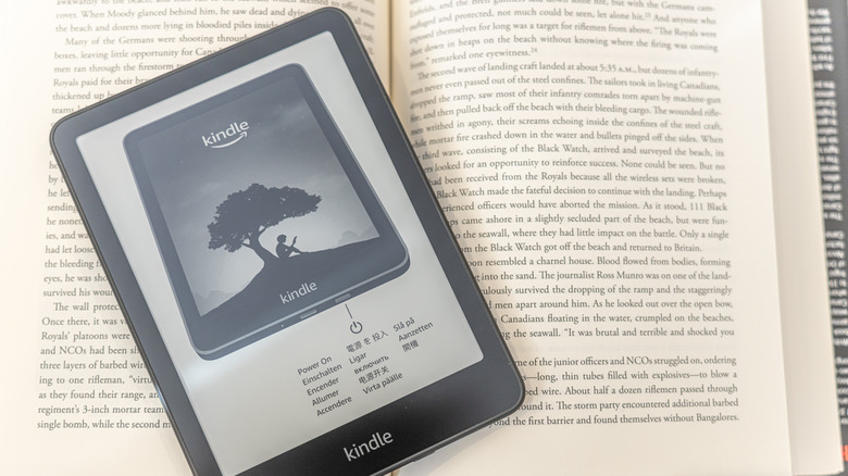 kindle powered off sitting on top of a physical book