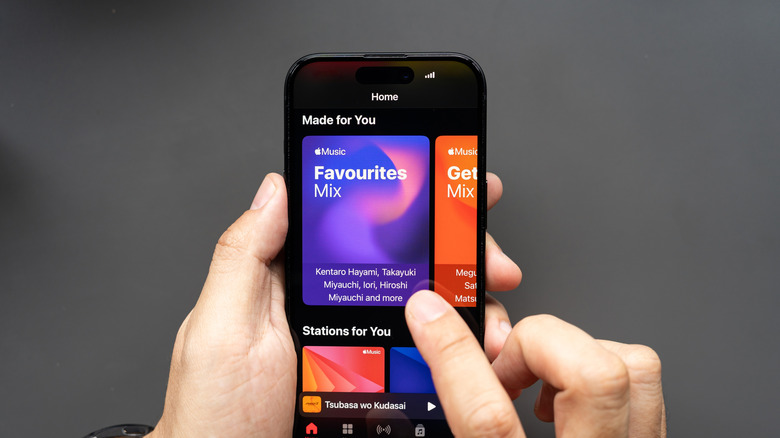 man using smartphone to browse apple music