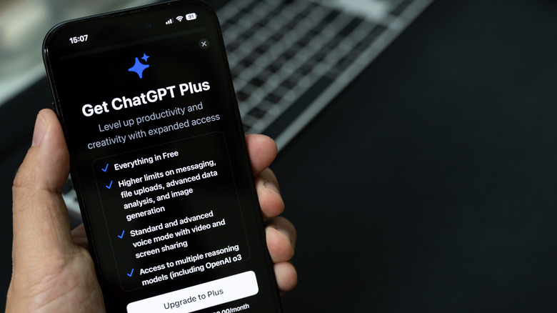 person holding smartphone with chatgpt plus subscription page visible