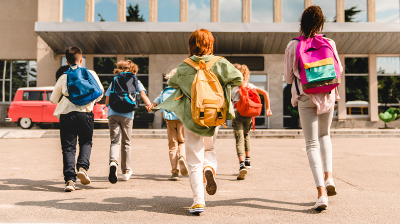 A group of kids running toward their school