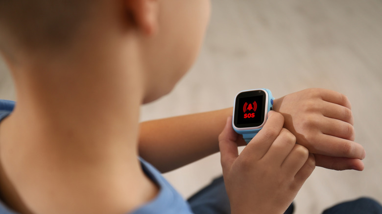 A kid using an SOS feature on his smartwatch