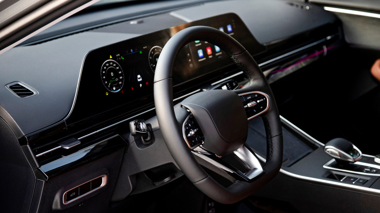 A car interior with physical controls present on the steering wheel.
