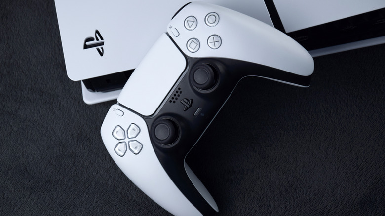 Close up of the PlayStation 5 with logo and a DualSense controller.