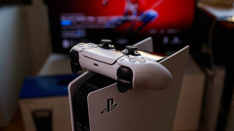 PlayStation 5 DualSense controller resting on top of a PS5 console.