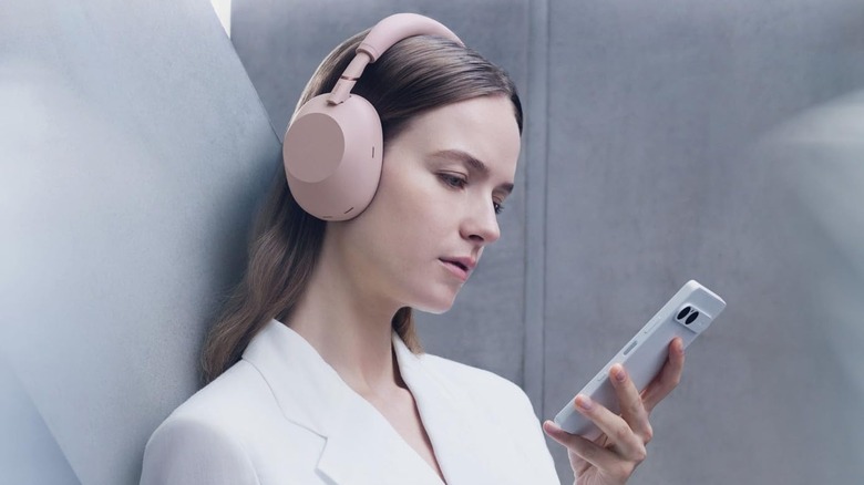 A woman wearing a pair of Sony WH-1000XM6 headphones.