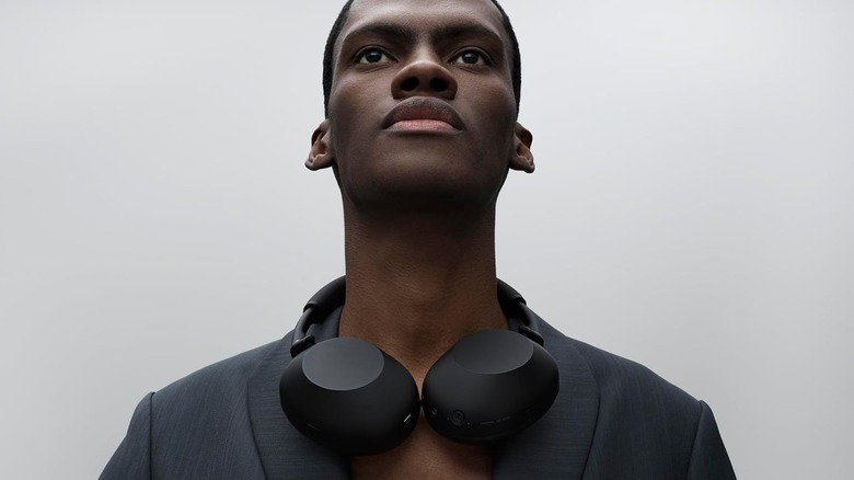 A man wearing a pair of Sony WH-1000XM6 headphones.