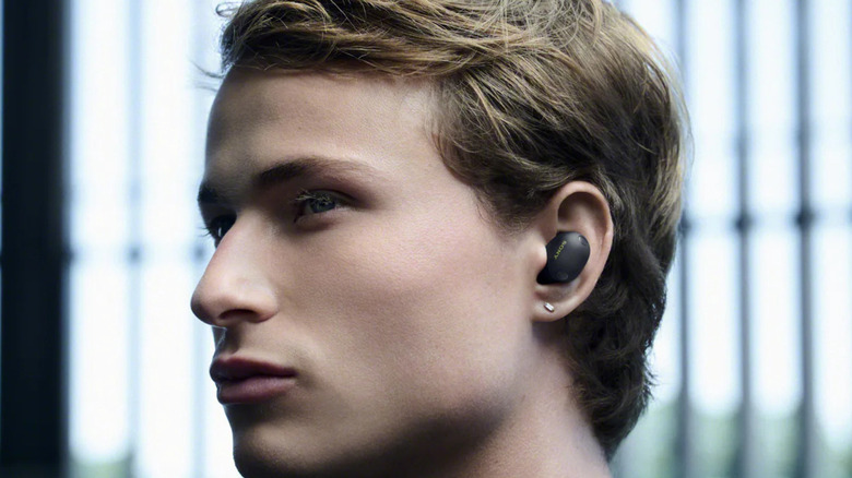 A man wearing Sony's new WF-100XM6 earbuds