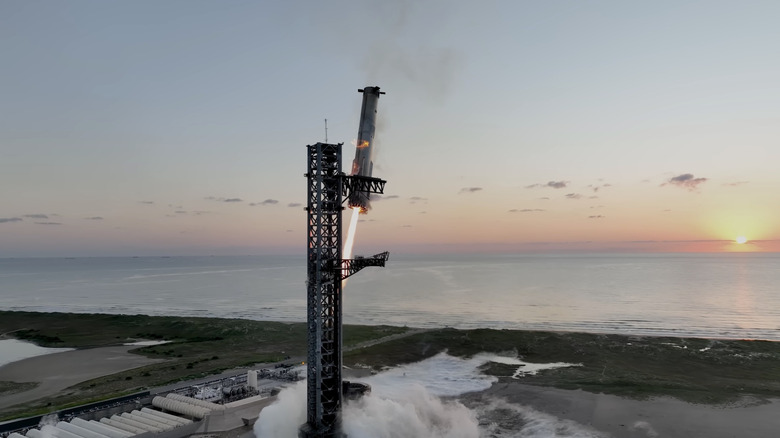 A Super Heavy booster returning to the launch tower at SpaceX's Starbase facility in Texas.