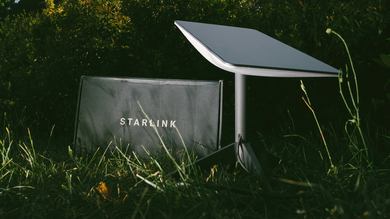 Starlink residential device with box set up in grass.