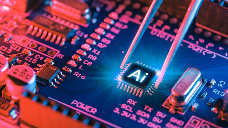 Close up of a microchip being placed on a motherboard with AI printed on it.
