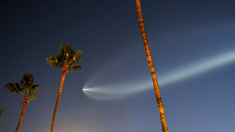 a Falcon 9 rocket launch visible in the sky