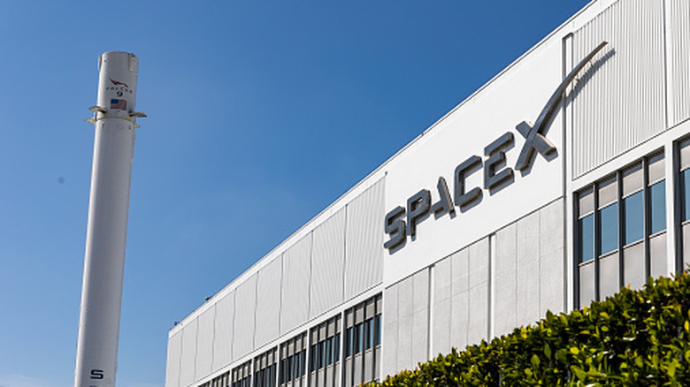 SpaceX headquarters with a Falcon 9 booster next to it