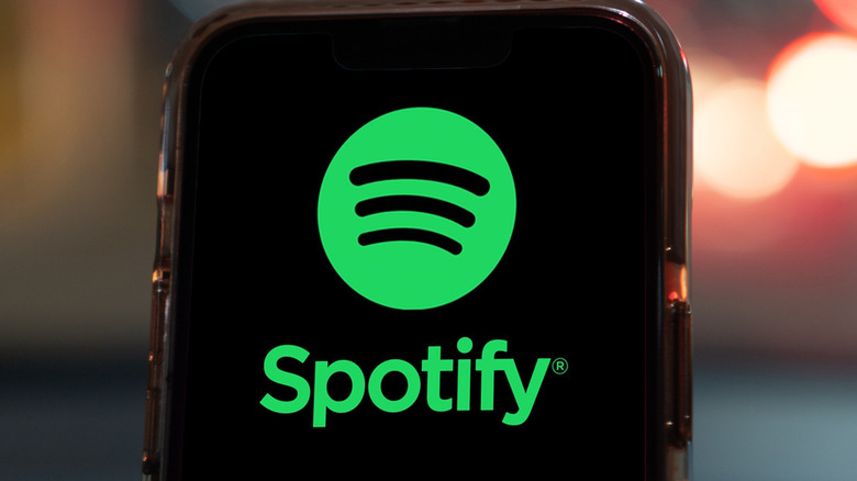 The Spotify logo appearing on a smartphone with a protective case