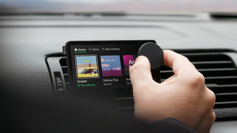 Spotify Car Thing in a car, being touched