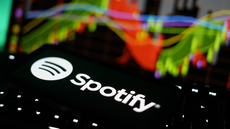 Spotify logo with colorful background and bright lighting.