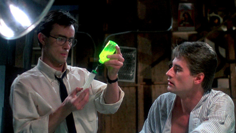 Herbert West (Jeffrey Combs) preparing a syringe while Dan Cain (Bruce Abbot) observes in "Re-Animator."