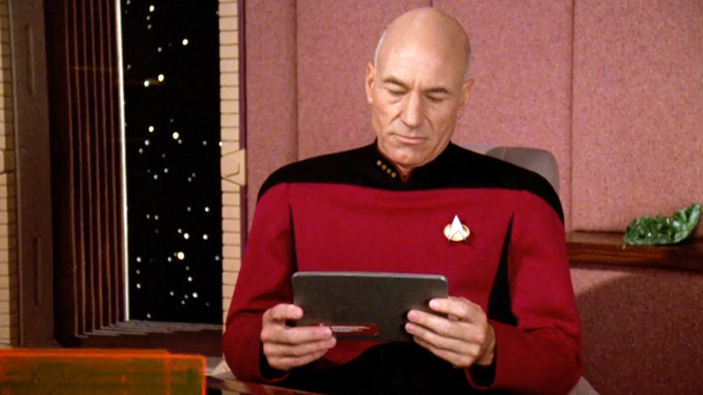 Captain Picard looking down at a PADD device