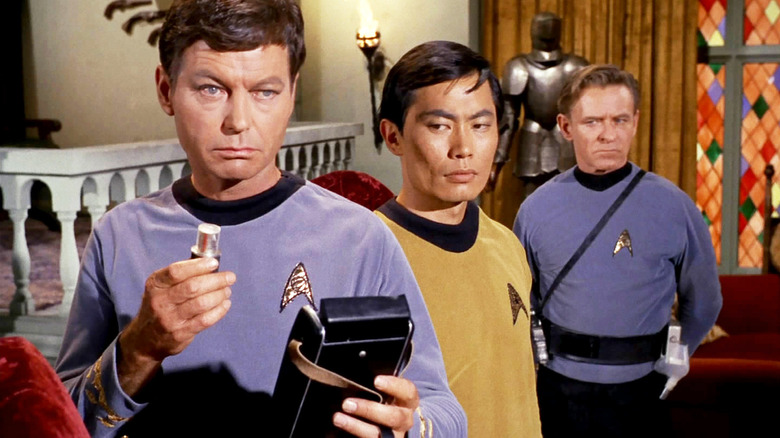 Doctor McCoy holding a medical tricorder from the show Star Trek