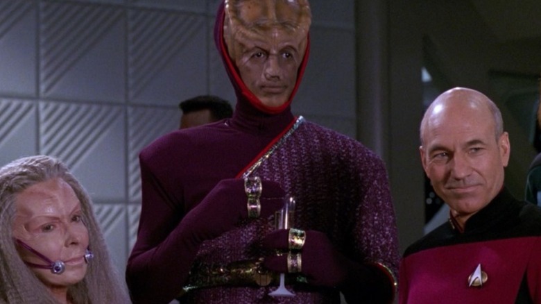 Bhavani (Elizabeth Hoffman) Leyor (Kevin Peter Hall) and Jean-Luc Picard talking in Star Trek: The Next Generation