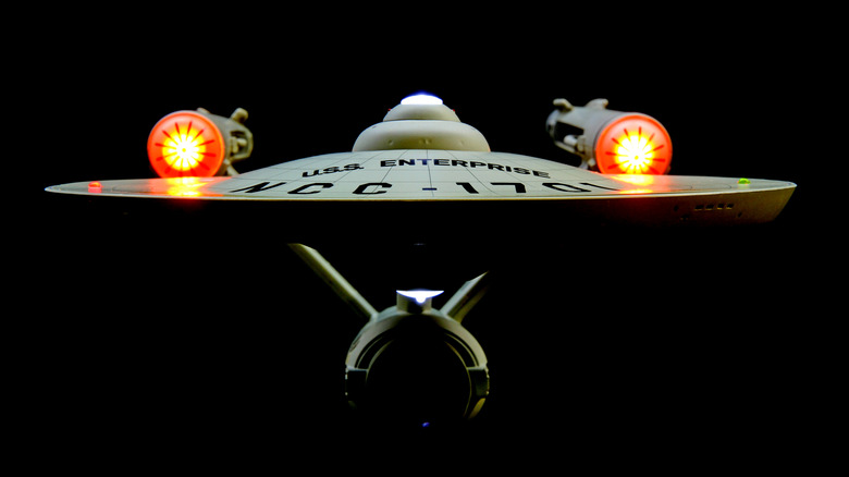 A front view of the U.S.S. Enterprise on a dark backdrop.